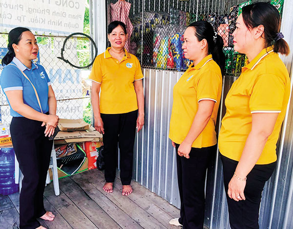 Chị Võ Thị Thúy Ðoan, Chủ tịch Hội LHPN quận Ô Môn (bìa trái), thăm hỏi việc mua bán, đời sống của các thành viên Tổ Phụ nữ mua bán nhỏ phường Thới An.