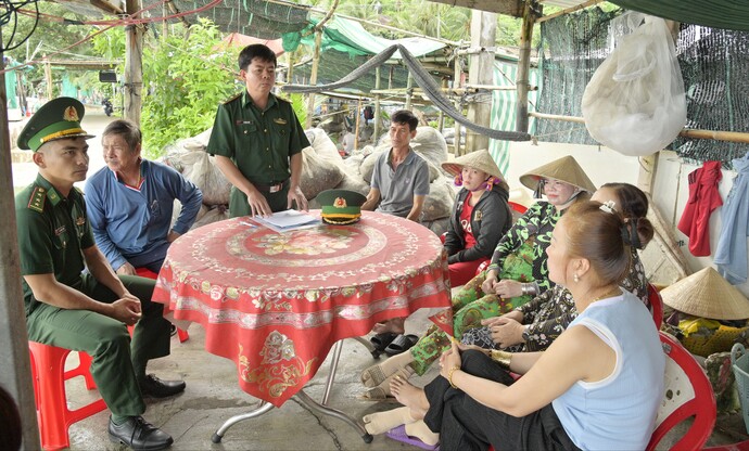 Trung tá Vũ Minh Tuân (đứng) trực tiếp tham gia tuyên truyền các văn bản pháp luật và kêu gọi người dân không khai thác hải sản trái phép trên vùng biển nước ngoài.