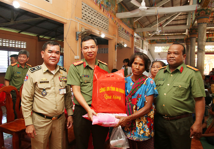 Đại tá Nguyễn Thanh Hà - Phó Giám đốc Công an tỉnh An Giang trao tặng quà cho người dân.