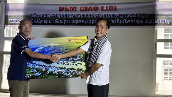 Ông Lê Phương Nguyên (bên trái) - Trường VPĐD Tạp chí Gia đình Việt Nam tại TP Cần Thơ tặng quà lưu niệm cho ông Hồ Hoàng Ca - PGĐ Vườn Quốc gia U Minh Hạ.