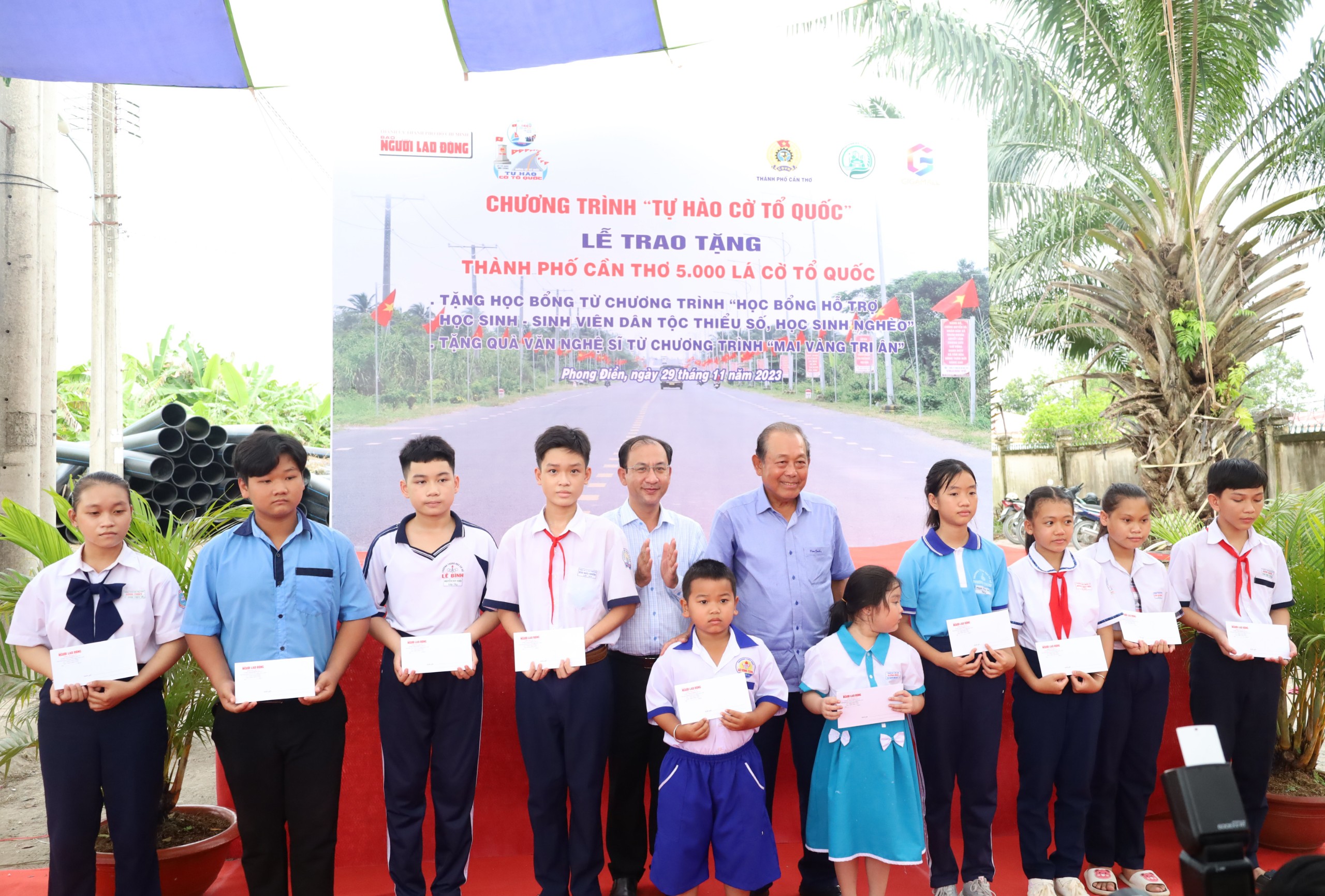 Ông Trương Hòa Bình – Nguyên Ủy viên Bộ Chính trị, Nguyên Phó Thủ Tướng Thường trực Chính phủ; Chủ tịch Danh dự chương trình”Tự hào Cờ Tổ quốc” và ông Nguyễn Trung Nghĩa - Chủ tịch UBND huyện Phong Điền trao tặng quà cho các em học sinh.