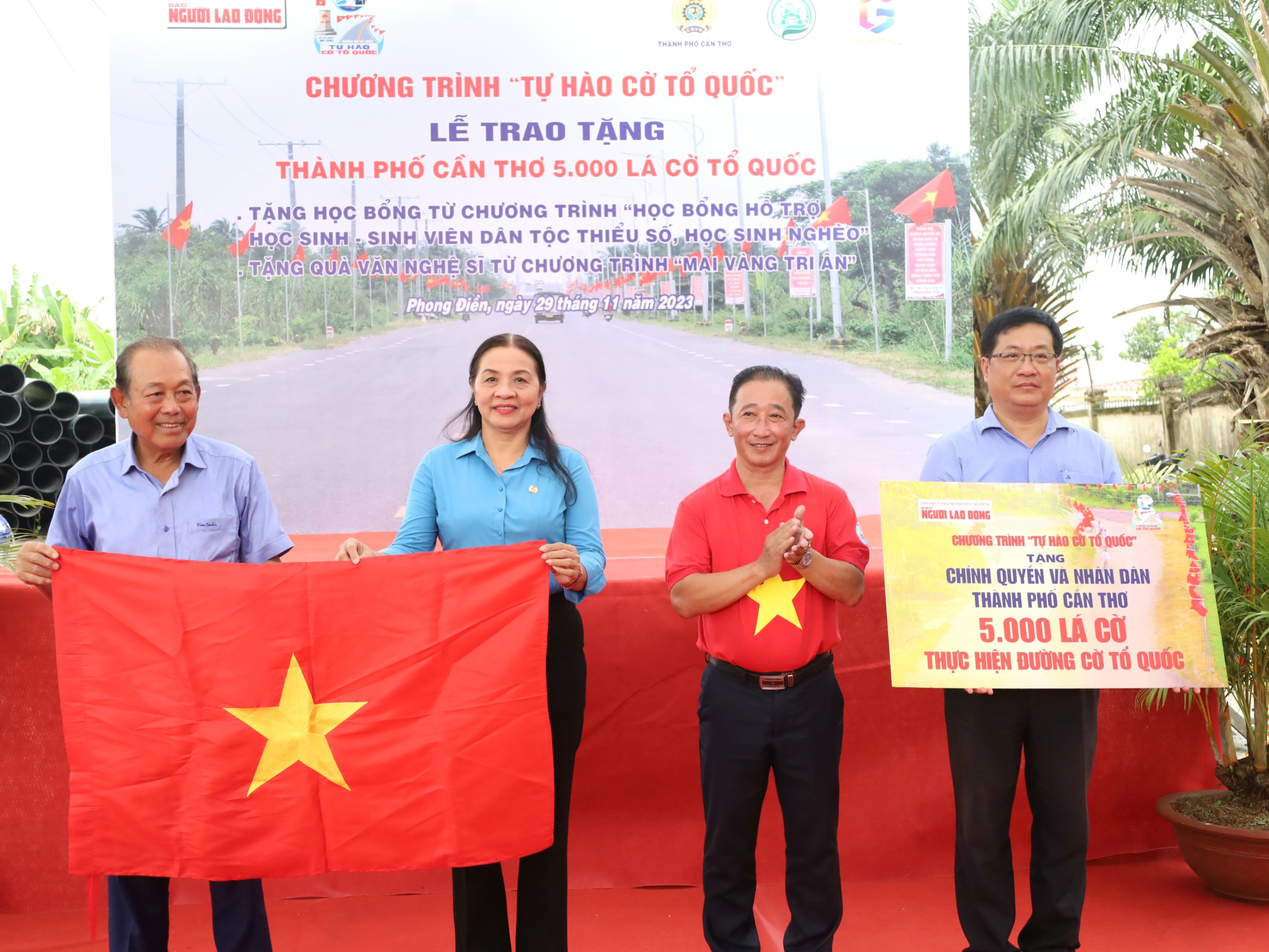 Ông Trương Hòa Bình – Nguyên Ủy viên Bộ Chính trị, Nguyên Phó Thủ Tướng Thường trực Chính phủ; Chủ tịch Danh dự chương trình”Tự hào Cờ Tổ quốc” và ông Bùi Thanh Liêm – Phó Tổng biên tập Báo Người Lao động trao cờ Tổ Quốc và bảng tượng trưng cho đại diện lãnh đạo huyện Phong Điền và lãnh đạo Liên đoàn Lao động TP. Cần Thơ.