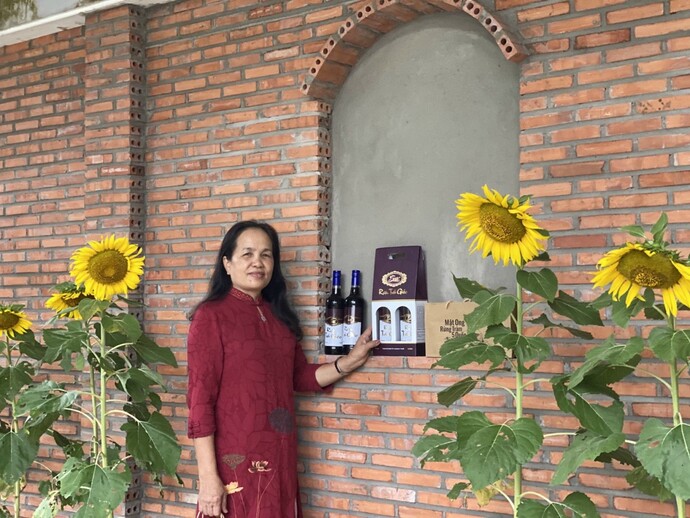 Bà Nguyễn Hồng Nhẫn, đại diện Công ty TNHH Thương mại Dịch vụ Du lịch sinh thái U Minh Hạ Huỳnh Quốc Sơn giới thiệu sản phẩm rượu trái giác.