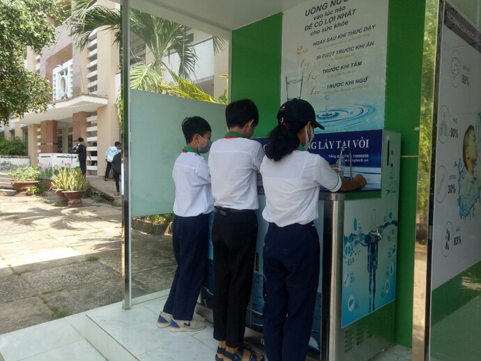 Các em học sinh trường THCS và THPT Khánh An, xã Khánh An thích thú khi sử dụng nước sạch từ máy lọc nước.