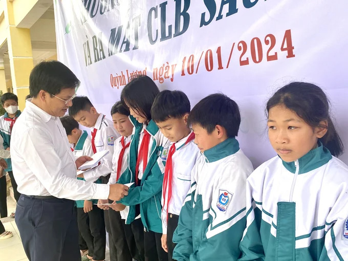 Nhà báo Hồ Minh Chiến - Tổng Biên tập Tạp chí Gia đình Việt Nam trao quà cho các học sinh có hoàn cảnh khó khăn tại trường THCS Minh - Lương