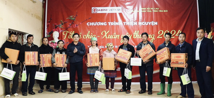 Nhà báo Hồ Minh Chiến cùng đại diện chính quyền xã trao quà cho các hộ dân xã Pá Lau