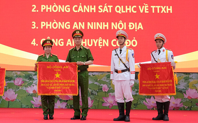 Lãnh đạo Bộ Công an tặng Cờ đơn vị xuất sắc, dẫn đầu phong trào thi đua Vì an ninh Tổ quốc cấp cơ sở cho Phòng Cảnh sát QLHC về TTXH Công an TP Cần Thơ (trái).