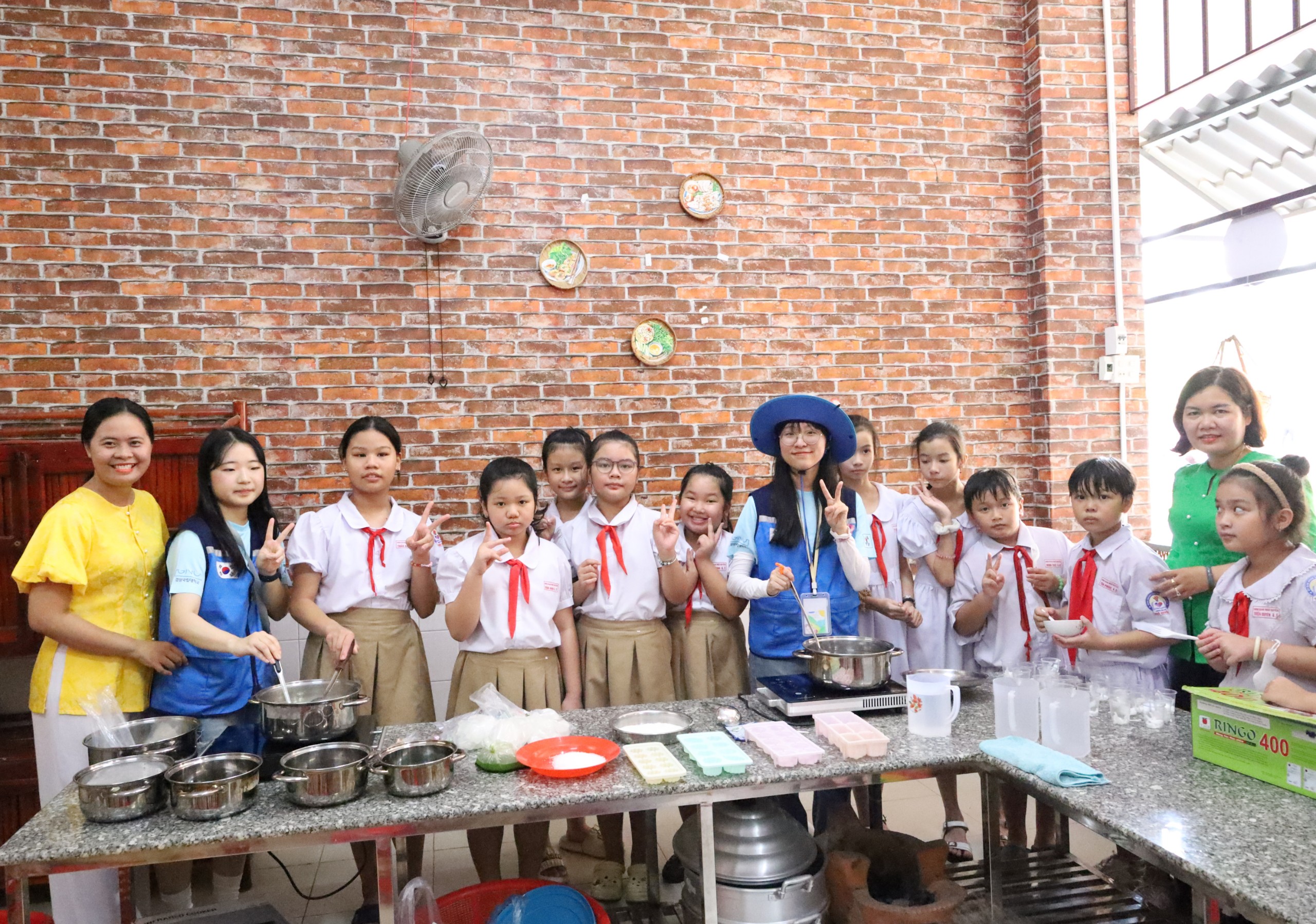 Giáo viên, học sinh Trường Tiểu học Ngô Quyền cùng sinh viên Hàn Quốc trải nghiệm làm bánh dân gian Nam bộ.