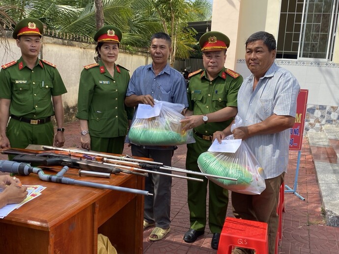 Thượng tá Đoàn Thanh Khải - Phó Trưởng Công an huyện Thới Bình (thứ 2 bên phải) trao tặng quà cho người dân đến giao nộp vũ khí.