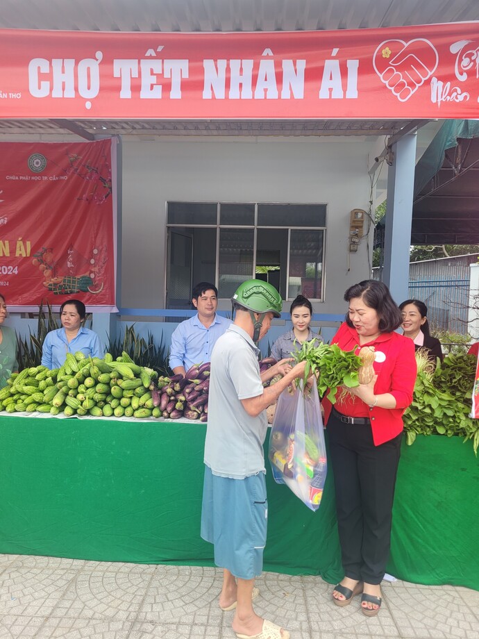 Bà Huỳnh Thanh Thảo - Chủ tịch Hội Chữ thập đỏ TP. Cần Thơ trao tận tay rau củ cho bà con khó khăn tại gian hàng chợ 'Tết nhân ái'