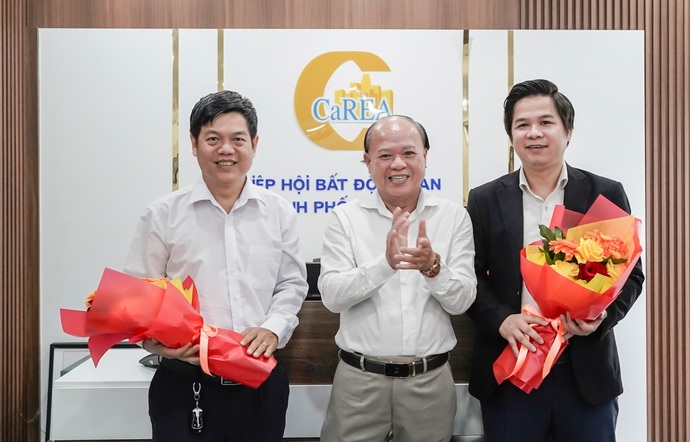 Ông Phạm Văn Luận, Phó Chủ tịch Hiệp hội Bất động sản TP Cần Thơ trao hoa cho ông Châu Thanh Bình và ông Đỗ Công Nguyên.