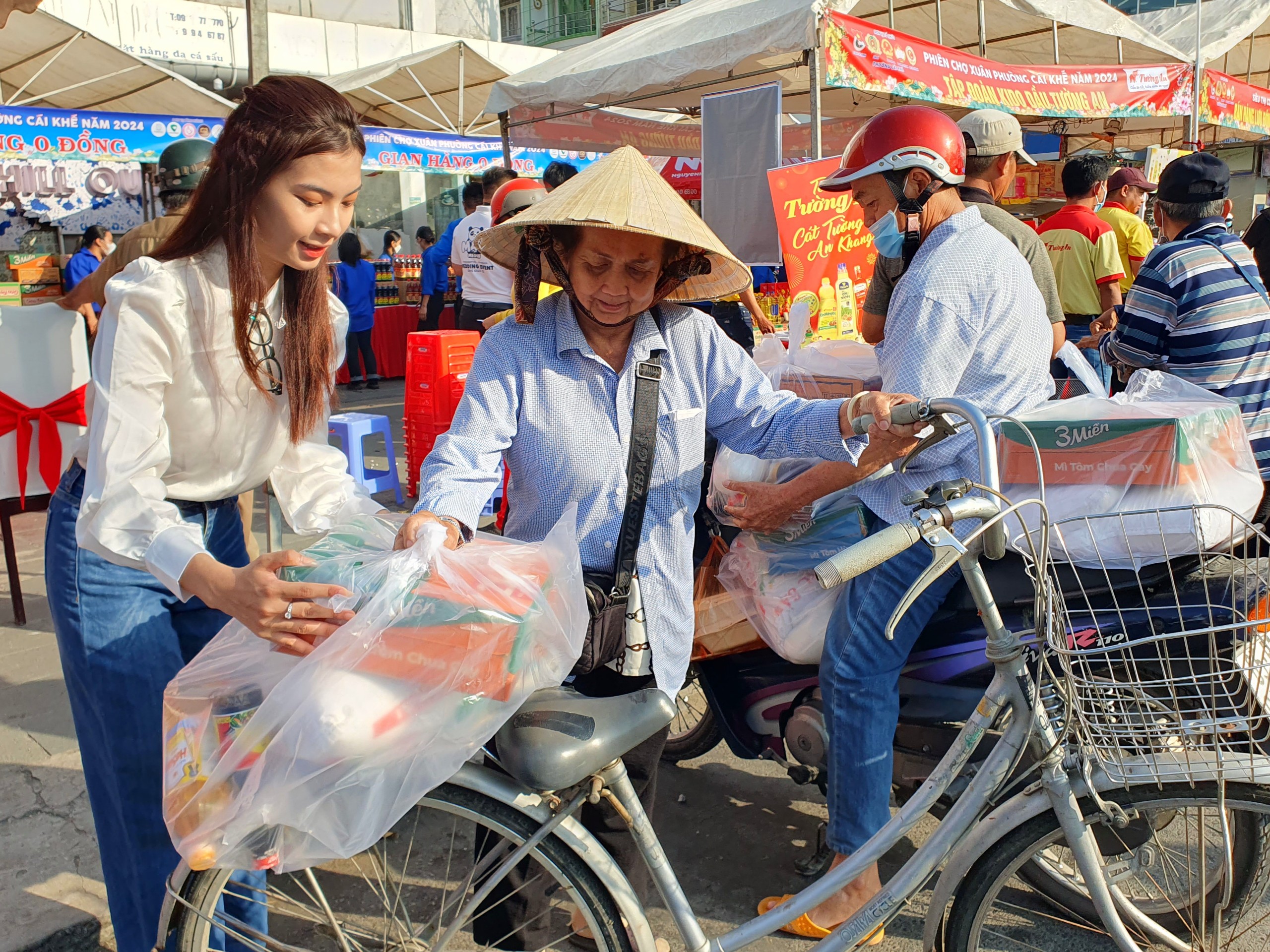 Hoa khôi Phan Lê Kim Ngọc - Hoa khôi Sinh viên TP Cần Thơ 2023 hỗ trợ mang quà Tết ra xe cho người dân.