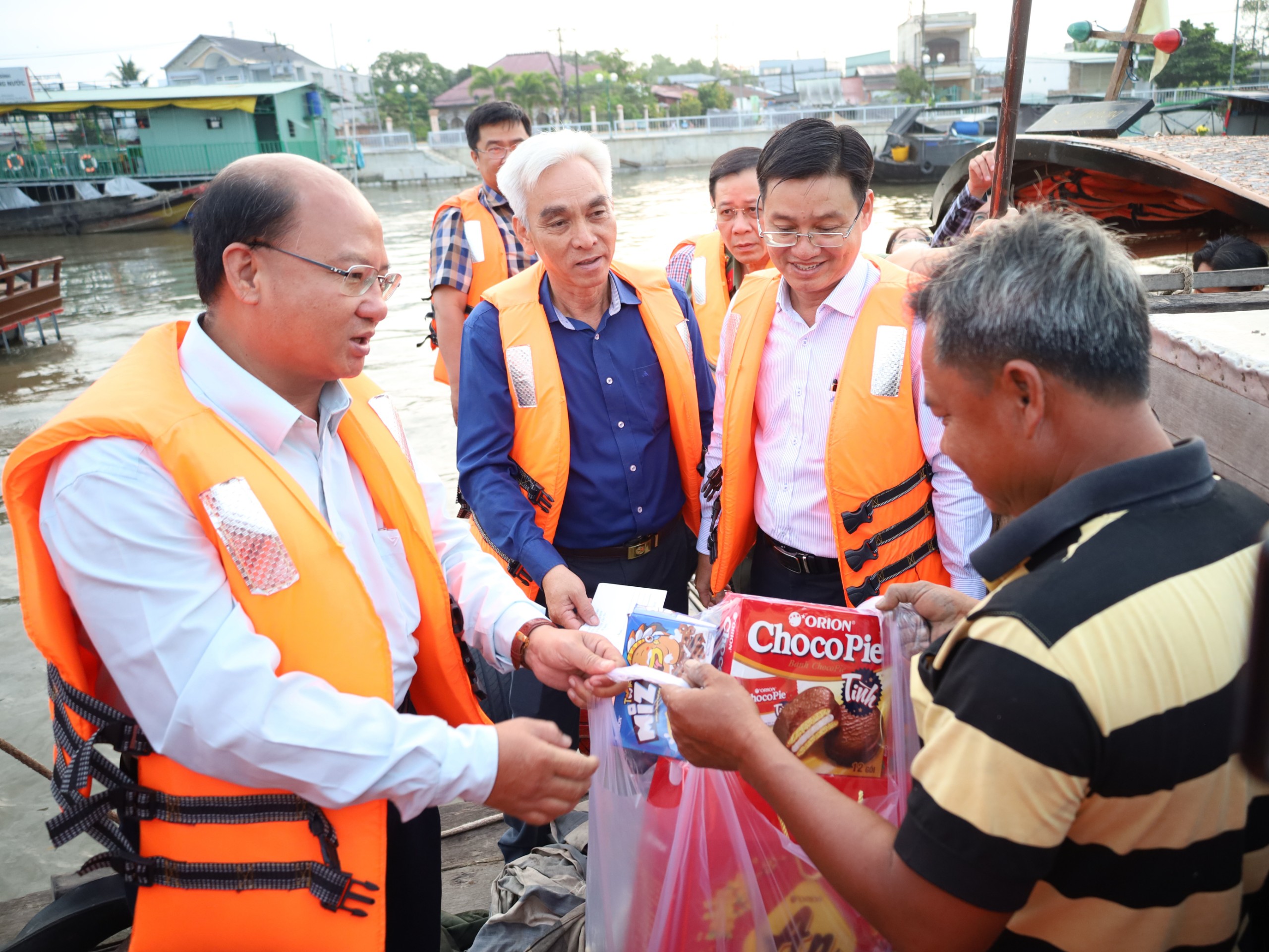 Ông Phan Văn Thép - Phó Trưởng ban Thường trực Ban Tuyên giáo Thành ủy Cần Thơ trao tặng quà cho thương hồ tại Chợ nổi Cái Răng.