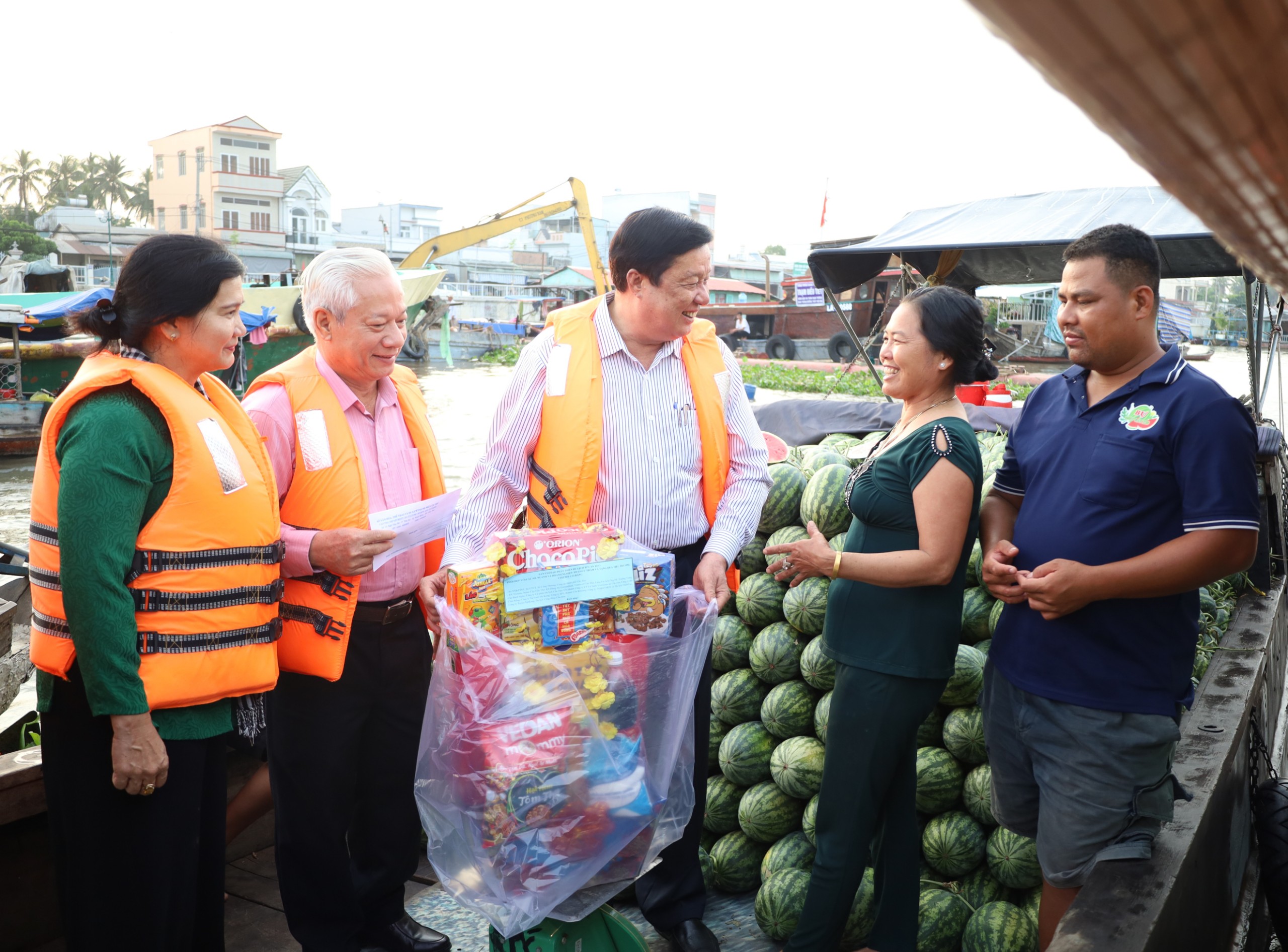 Ông Phạm Văn Hiểu - Phó Bí thư Thường trực Thành ủy, Chủ tịch HĐND TP. Cần Thơ trò chuyện, thăm hỏi và trao tặng quà cho thương hồ mua bán tại Chợ nổi Cái Răng.