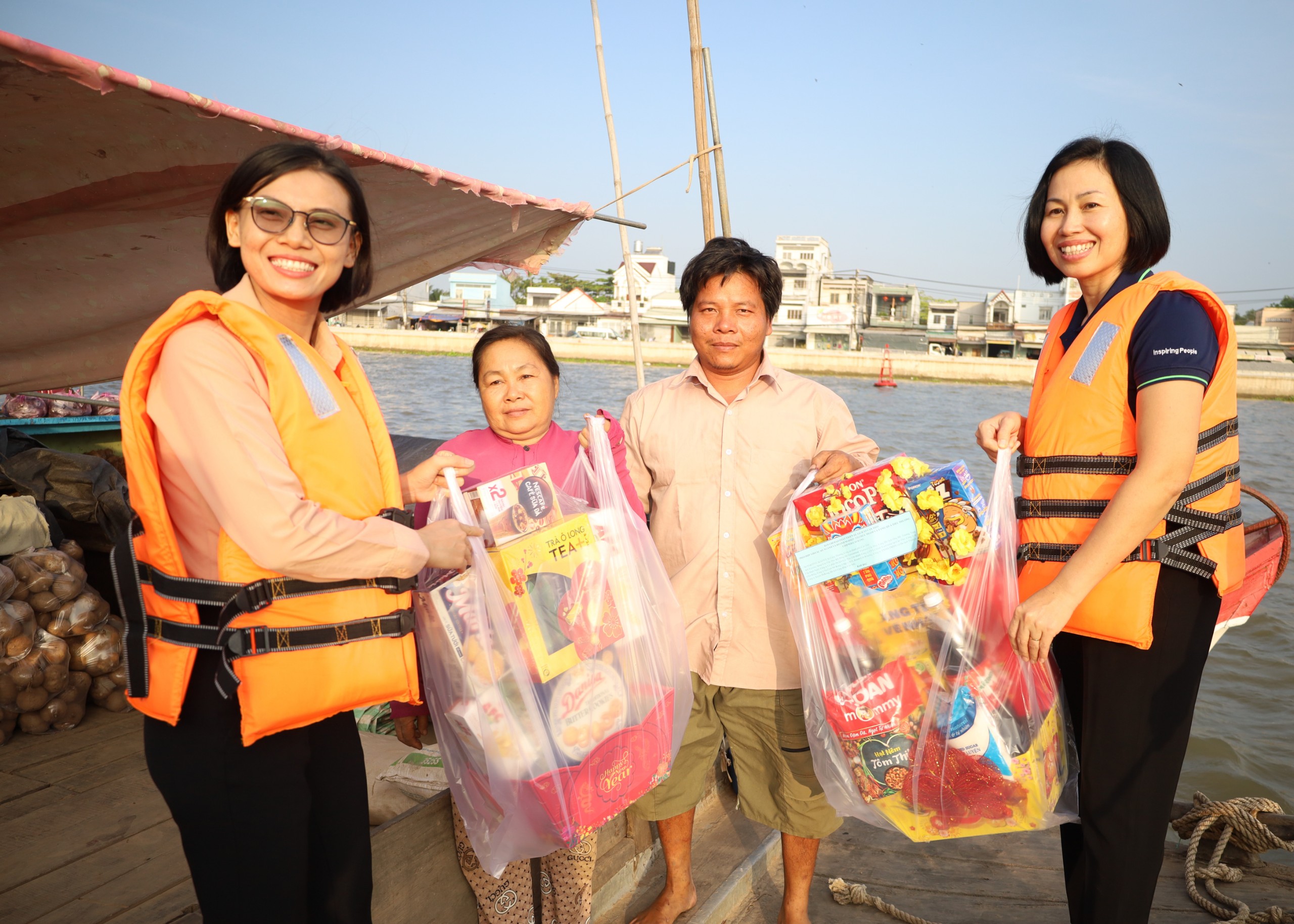 Bà Võ Xuân Thư (bìa phải) - Giám đốc Victoria Cần Thơ Resort tặng quà cho thương hồ tại Chợ nổi Cái Răng.