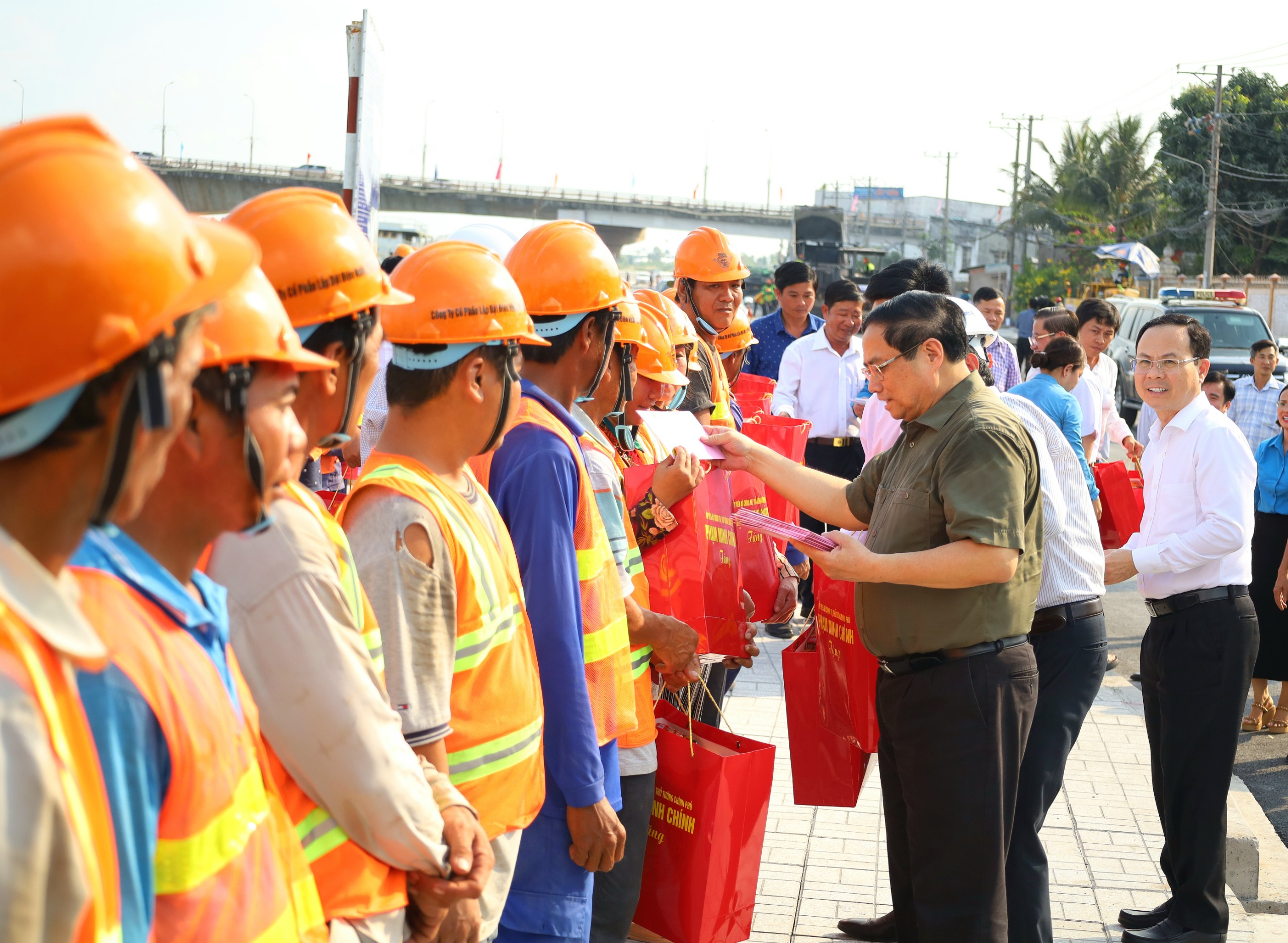 Thủ tướng Chính phủ Phạm Minh Chính tặng quà cho công nhân đang thi công tuyến đê kè, ứng phó biến đổi khí hậu TP. Cần Thơ tại công trường.