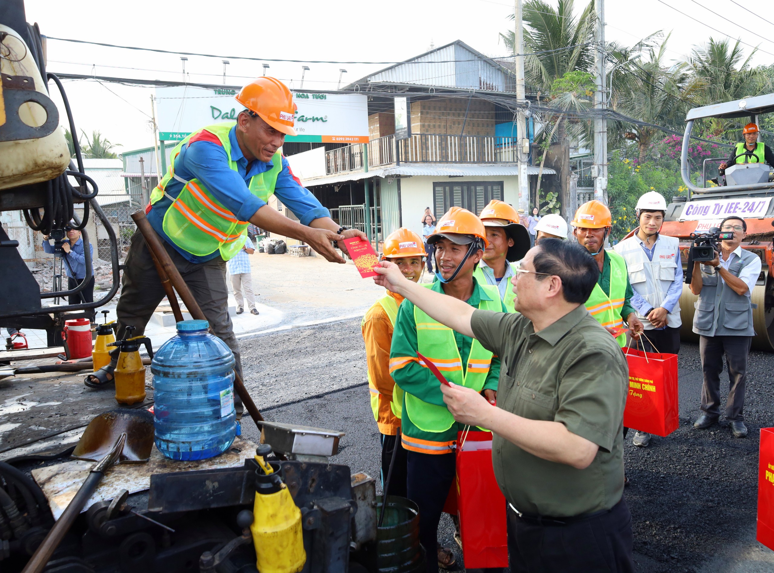 Thủ tướng Chính phủ Phạm Minh Chính tặng lì xì cho công nhân đang thi công tuyến đê kè, ứng phó biến đổi khí hậu TP. Cần Thơ tại công trường.