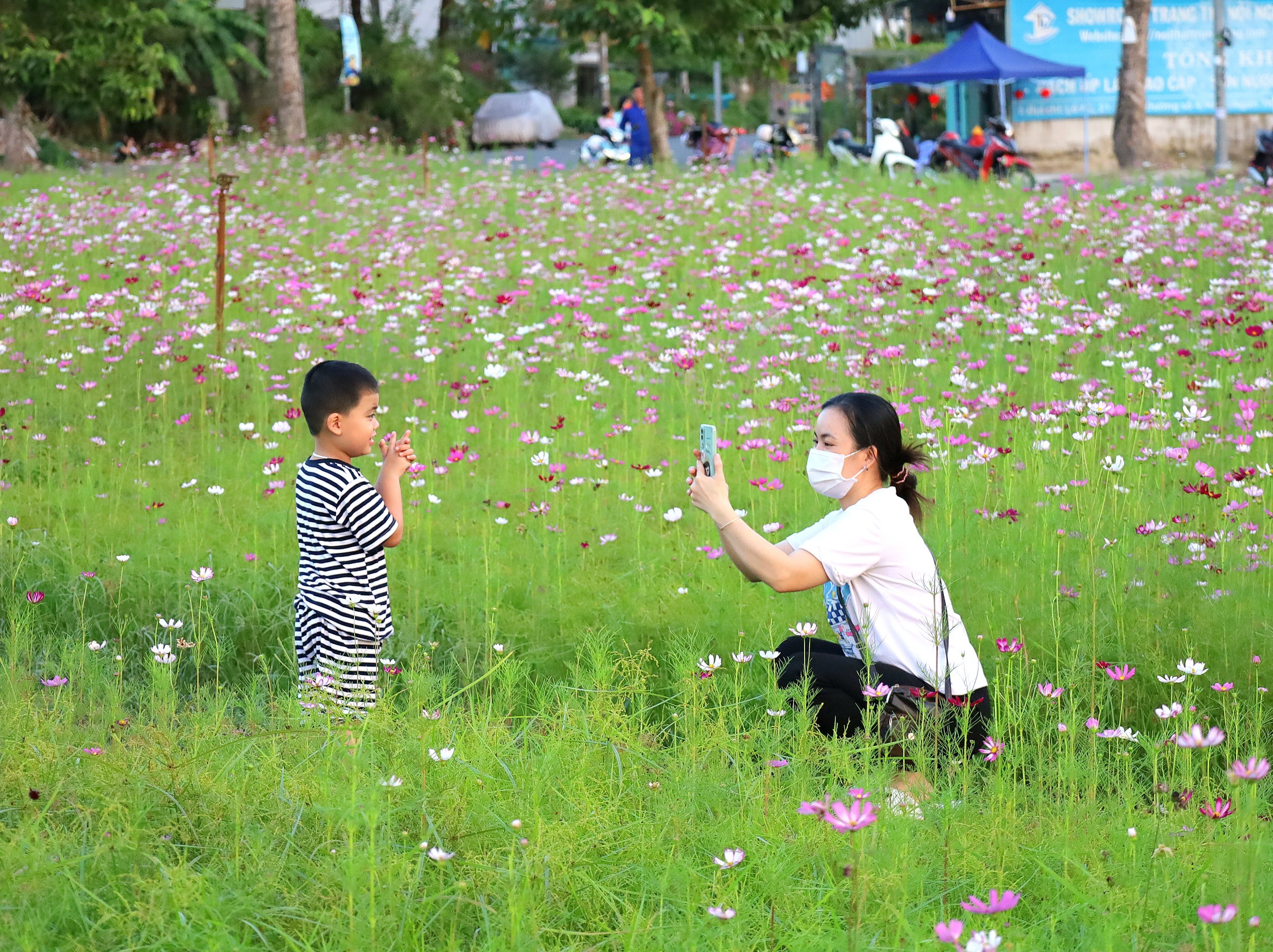 Phụ huynh tranh thủ chụp hình cho con tại vườn hoa.