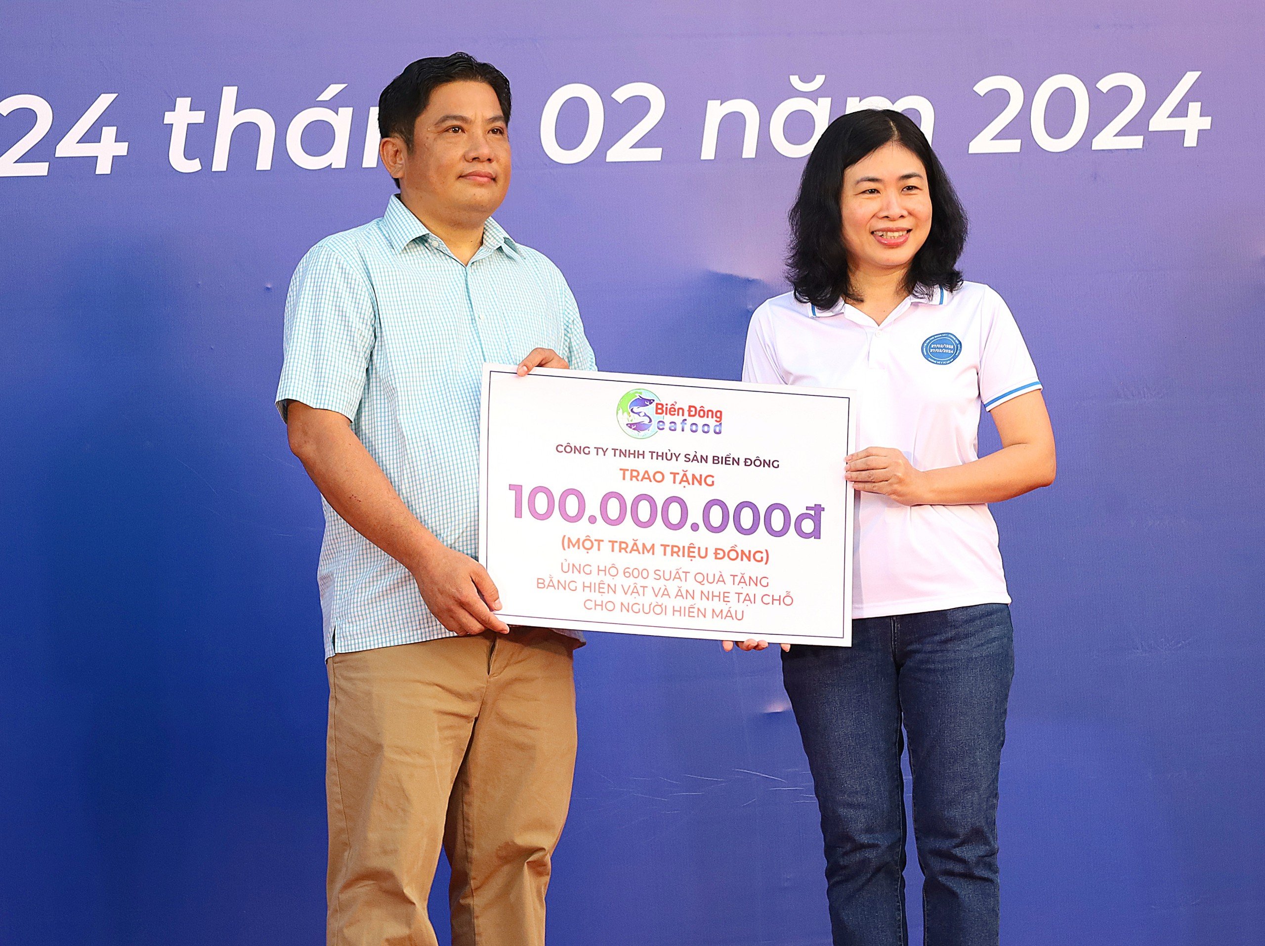 Đại diện Công ty TNHH Thủy sản Biển Đông trao bảng tượng trưng ủng hộ 600 suất quà tặng bằng hiện vật và ăn nhẹ tại chỗ cho người hiến máu.
