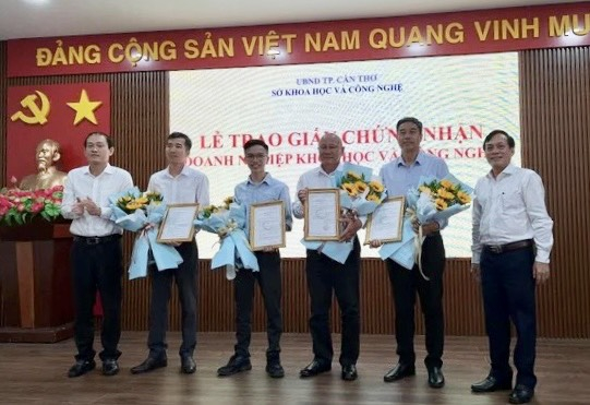 Ông Nguyễn Ngọc Hè - Thành ủy viên, Phó Chủ tịch UBND TP. Cần Thơ (bìa phải) và ông Ngô Anh Tín - Giám đốc Sở KH&CN thành phố (bìa trái) trao giấy chứng nhận KH&CN cho các doanh nghiệp mới trên địa bàn TP Cần Thơ.