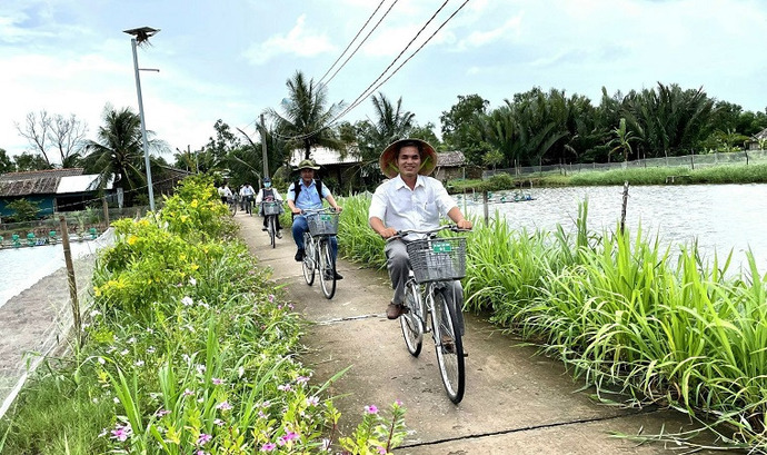 Du khách đạp xe giữa ruộng lúa tôm Cồn Chim.