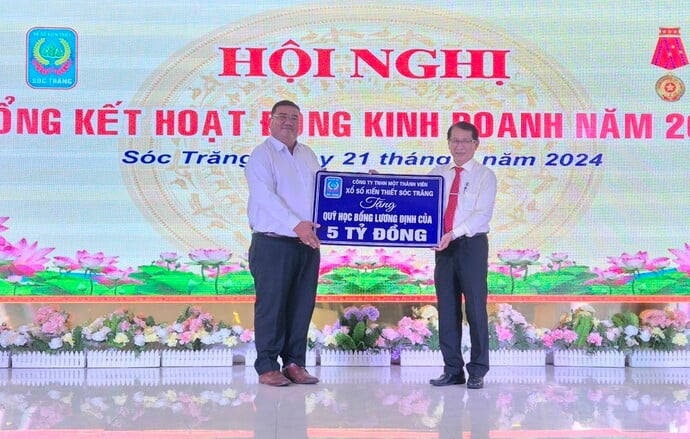 Ông Lâm Dủ Nhơn (bìa phải) - Chủ tịch Công ty TNHH XSKT Sóc Trăng trao 5 tỷ đồng tài trợ học bổng Lương Định Của.