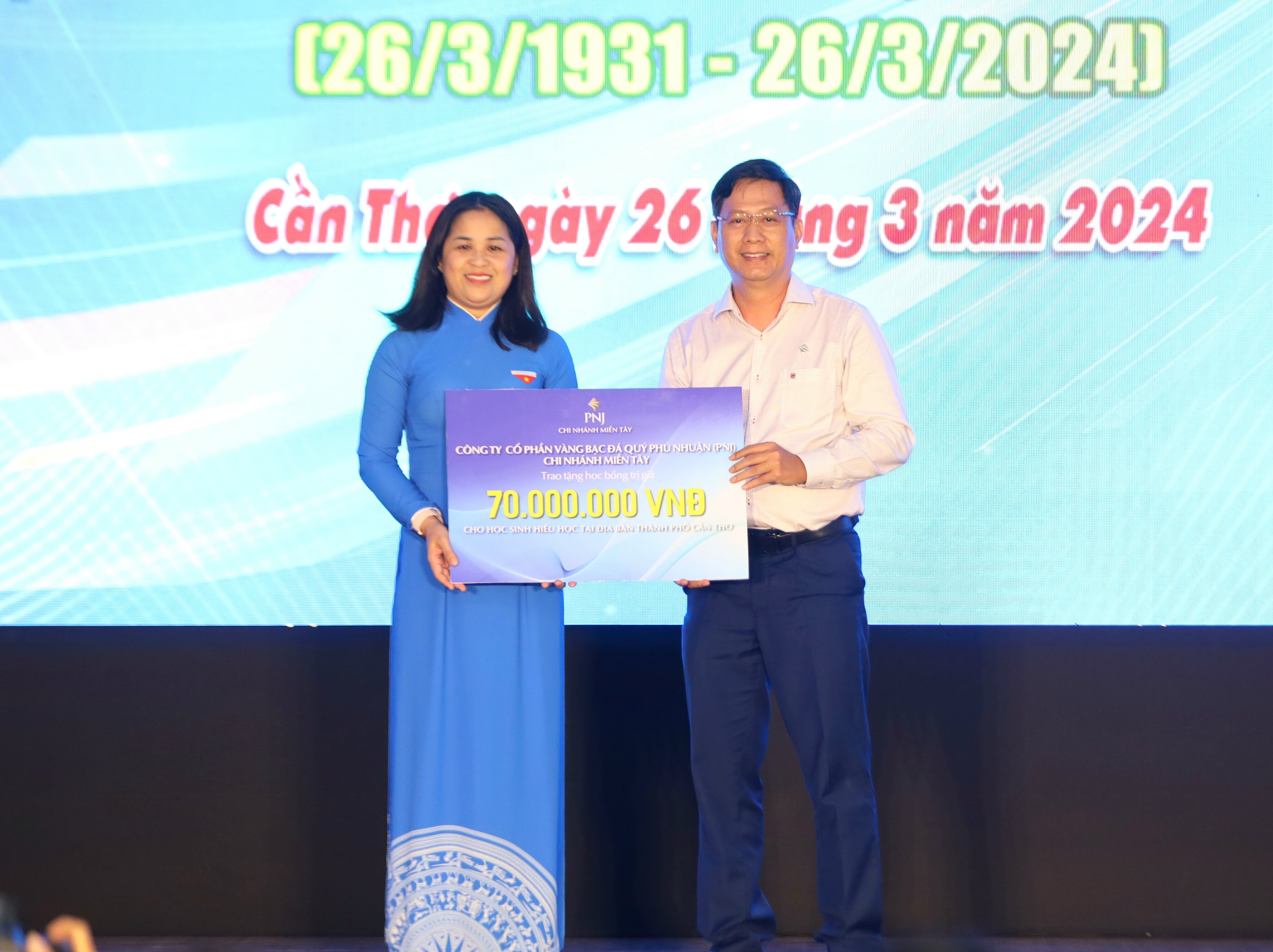 Ông Nguyễn Ngọc Huy - Giám đốc Chi nhánh PNJ Miền Tây trao bảng tượng trưng tặng 35 suất học bổng trị giá 70 triệu đồng cho học sinh có hoàn cảnh khó khăn.