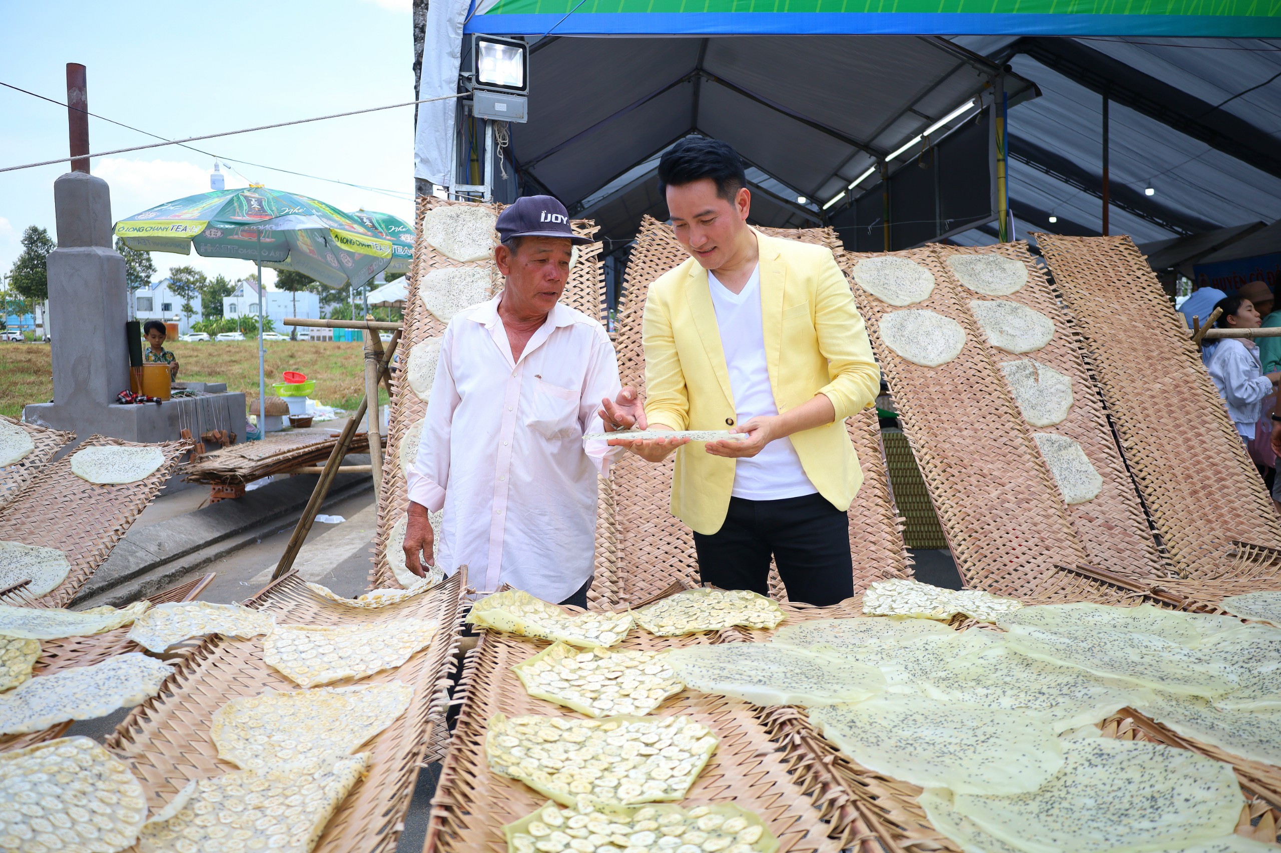 Ca sĩ Nguyễn Phi Hùng cùng nghệ nhân của làng nghề làm bánh tráng Thuận Hưng - Di sản văn hóa phi vật thể quốc gia.