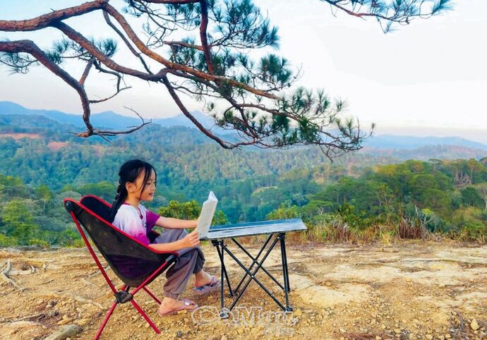 Sau khi đến điểm nghỉ ngơi, bé An Bình ngồi đọc sách tận hưởng không khí yên bình.