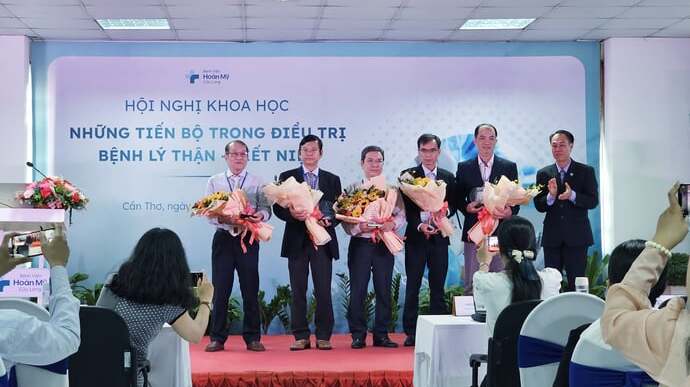TS.BS Nguyễn Phi Hùng - Giám đốc chuyên môn Bệnh viện Hoàn Mỹ Cửu Long trao hoa cho các chuyên gia, bác sĩ tại hội nghị.