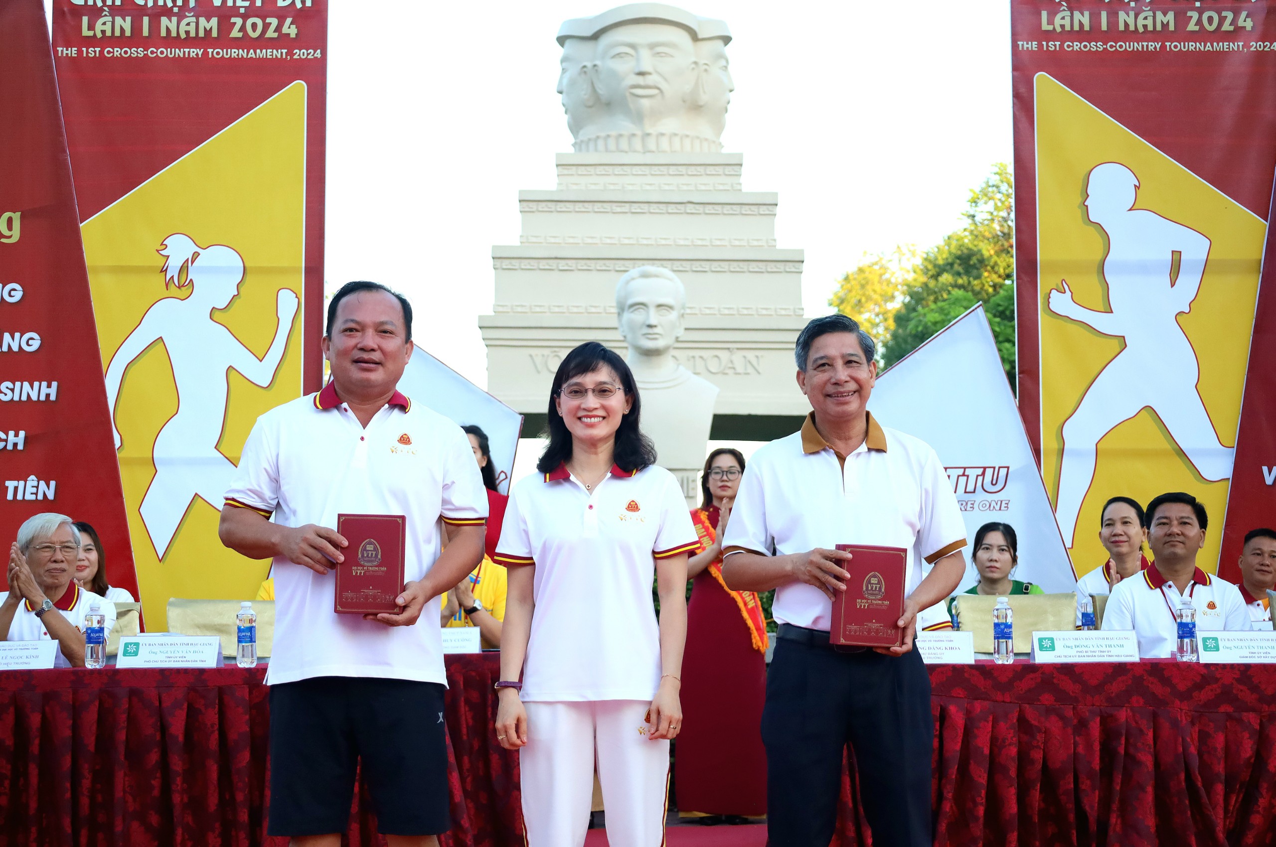 Tiến sĩ Hoàng Kim Thoa - Chủ tịch Hội đồng Trường Đại học Võ Trường Toản tặng quà lưu niệm cho ông Đồng Văn Thanh - Phó Bí thư Tỉnh ủy, Chủ tịch UBND tỉnh Hậu Giang và ông Nguyễn Văn Hoà - Phó Chủ tịch UBND tỉnh Hậu Giang.