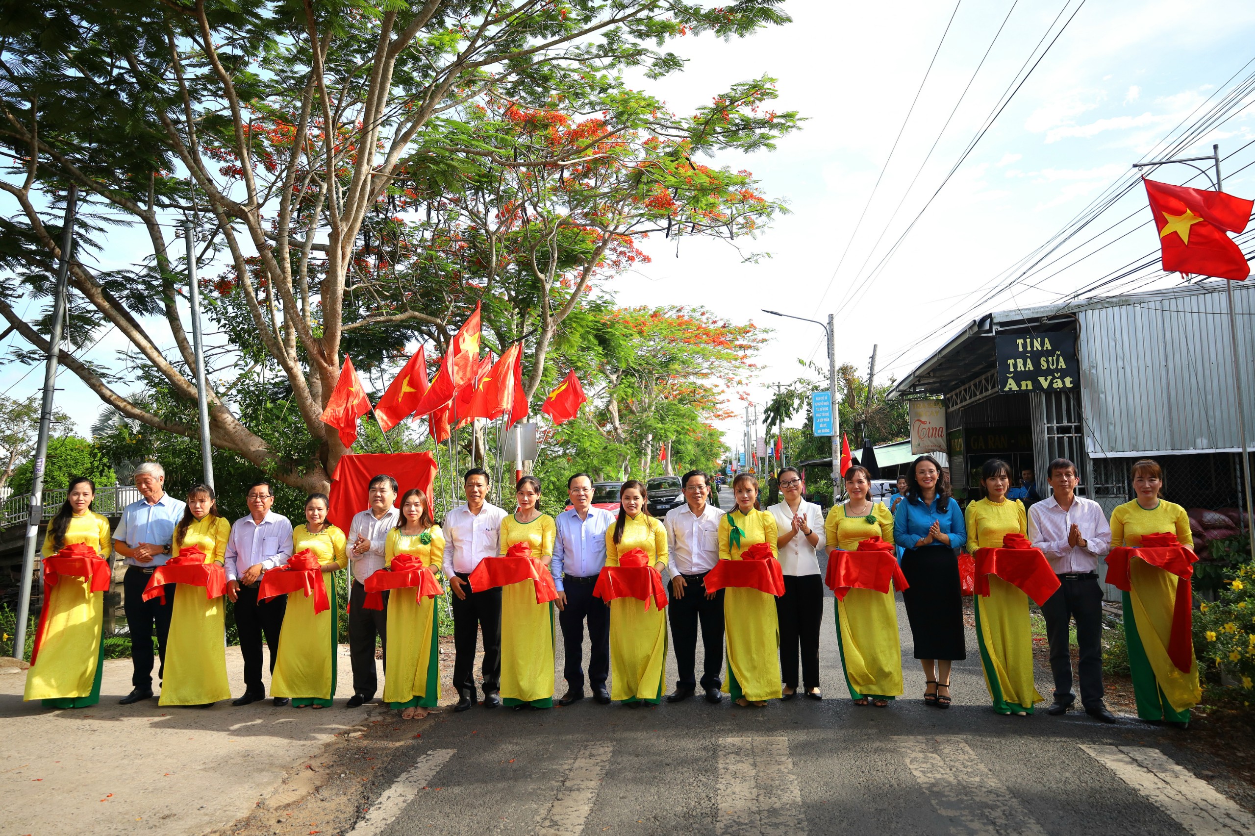 Các đại biểu thực hiện nghi thức cắt băng khánh thành “Đường cờ Tổ quốc” tại huyện Thới Lai.