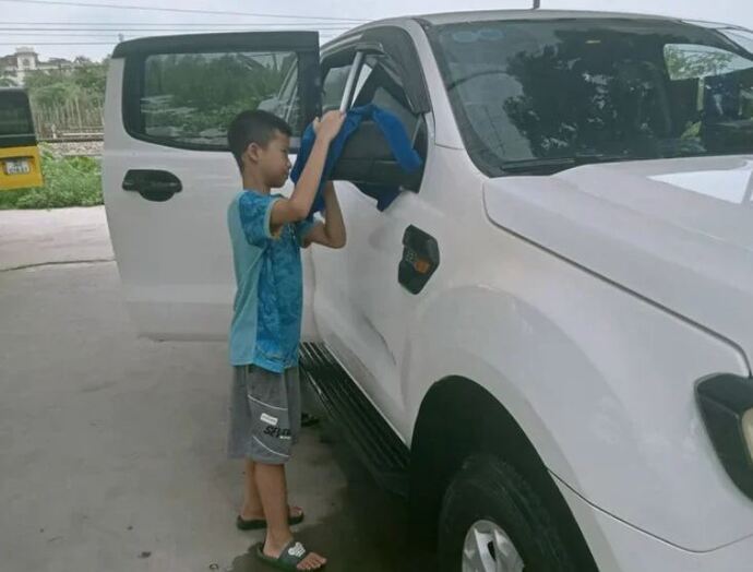 Thái Sơn, 11 tuổi trải nghiệm tại một tiệm rửa xe cách nhà 5km. Ảnh: gia đình cung cấp