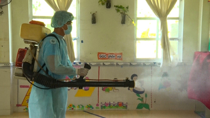 Cán bộ Trung tâm y tế thành phố Vị Thanh phun thuốc diệt khuẩn tại các điểm trường. (Ảnh: haugianggov)