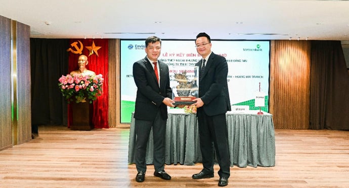 Ông Hồ Văn Tuấn - Phó Tổng Giám đốc Vietcombank và ông John Lee - Tổng Giám đốc khu vực châu Á và châu Phi của Tập đoàn Envision trao quà và chụp ảnh lưu niệm tại sự kiện