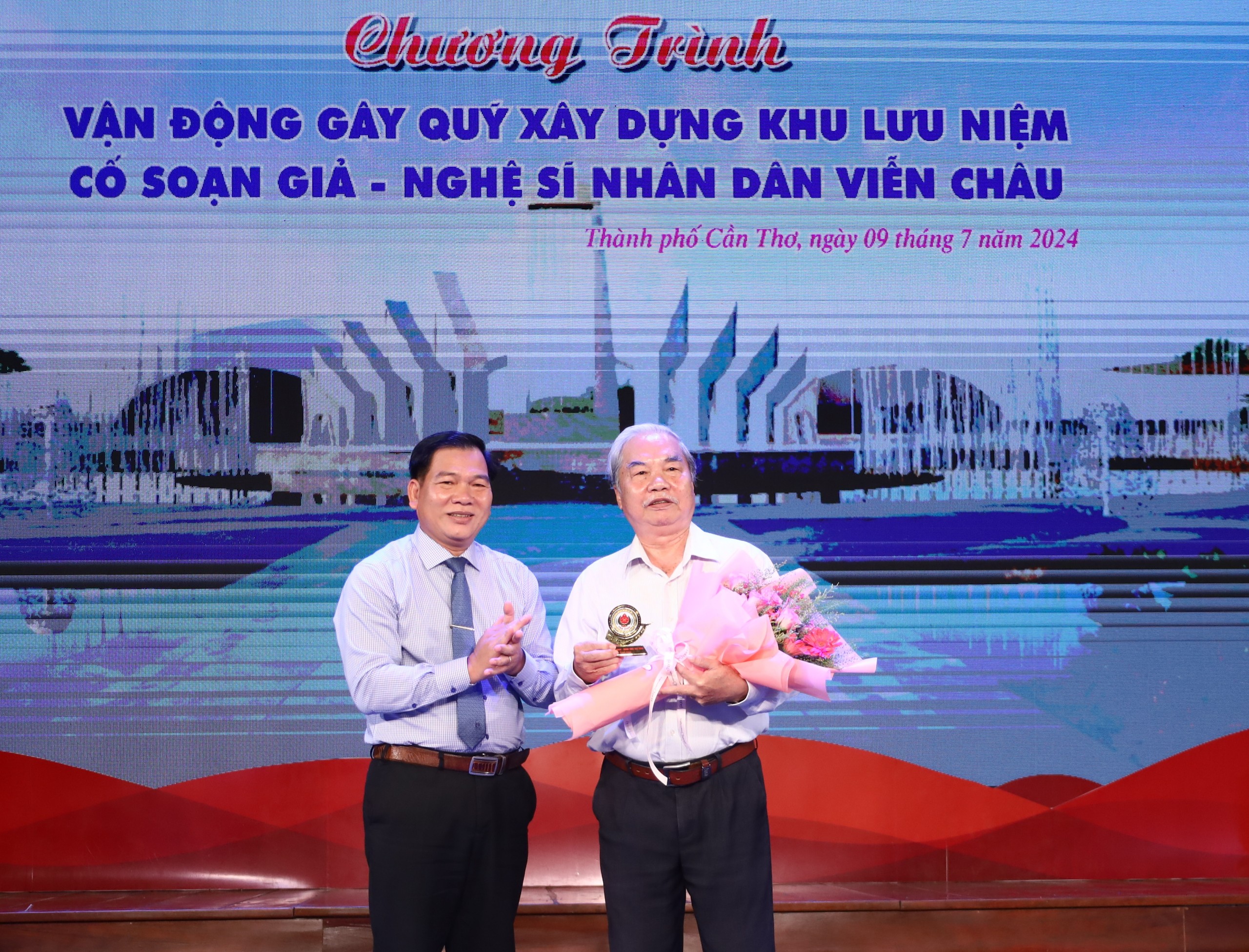 Ông Dương Hoàng Sum - Giám đốc Sở Văn hóa - Thể thao và Du lịch tỉnh Trà Vinh, Phó Trưởng Ban Thường trực Ban vận động trao tặng hoa cho Soạn giả Nhâm Hùng - Nhà nghiên cứu Văn hóa Nam bộ.