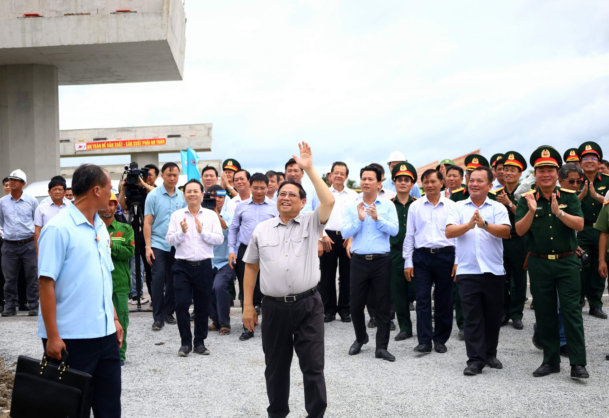 Thủ tướng Chính phủ Phạm Minh Chính động viên các công nhân đang thi công khu vực trên cao tại Nút giao QL61C, xã Bình Thành, huyện Phụng Hiệp, tỉnh Hậu Giang.