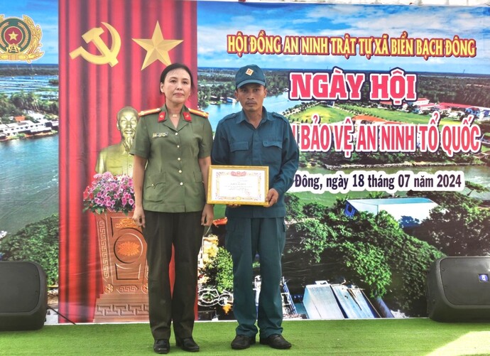 Thượng tá Lê Kiều Oanh - Phó Bí thư Đảng ủy, Phó Trưởng Công an huyện Thới Bình, Cà Mau trao tặng giấy khen ' Toàn dan bảo vệ an ninh tổ quốc' năm 2024 của UBND huyện.