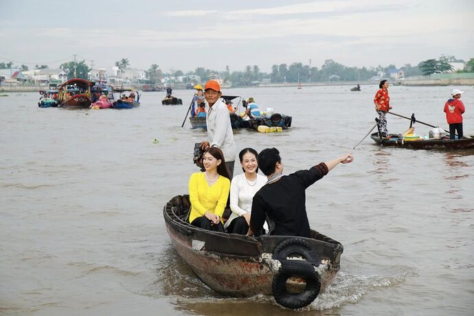 Du khách phấn khởi khi trải nghiệm tham quan chợ nổi bằng ghe, xuồng. Ảnh: Phương Trọng.