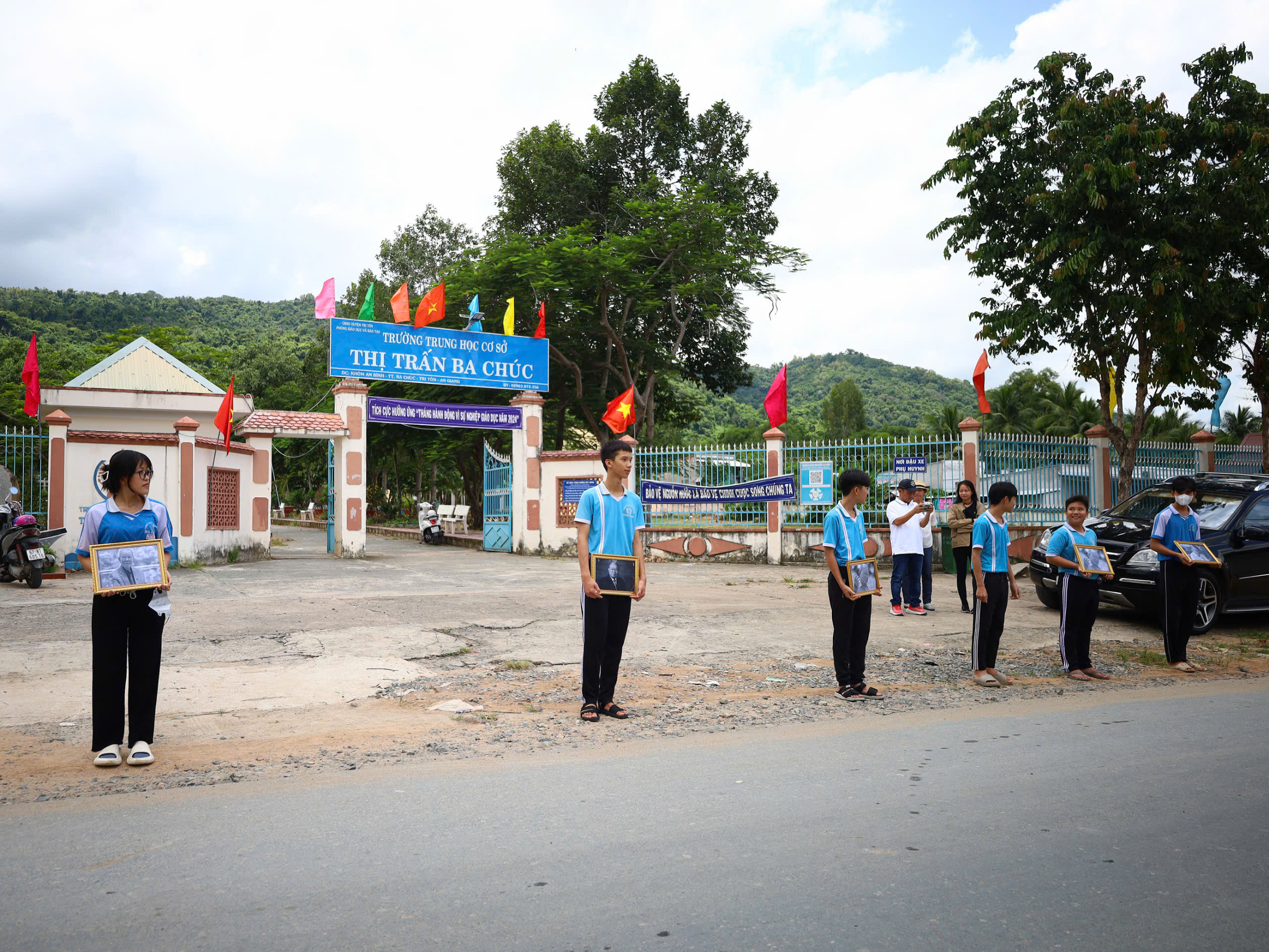 Học sinh Trường THPT Ba Chúc, huyện Tri Tôn mang theo di ảnh đứng chờ tiễn biệt GS, TS, AHLĐ, NGND Võ Tòng Xuân.