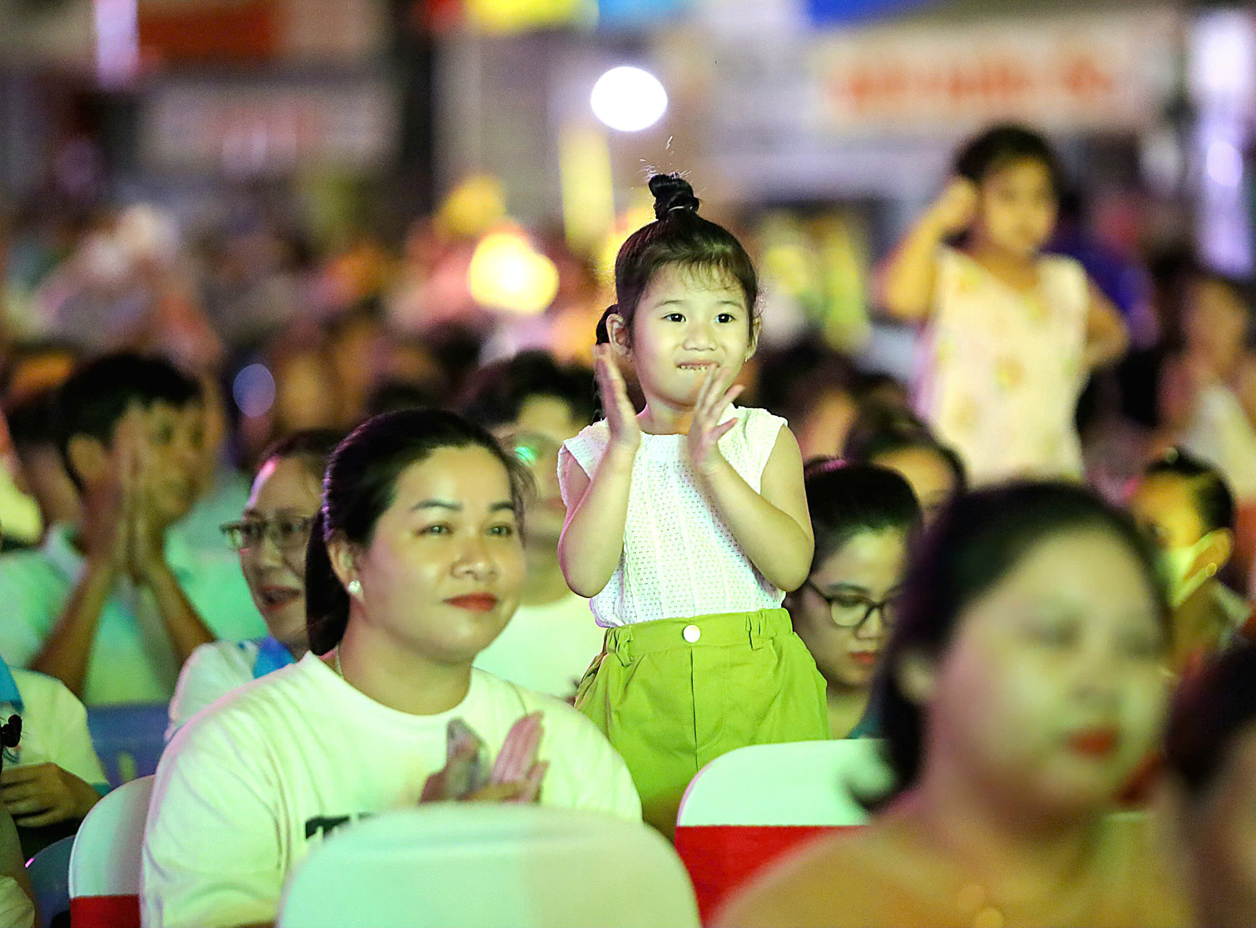 Các em thiếu nhi thích thú khi được người lớn dẫn đi xem chương trình.