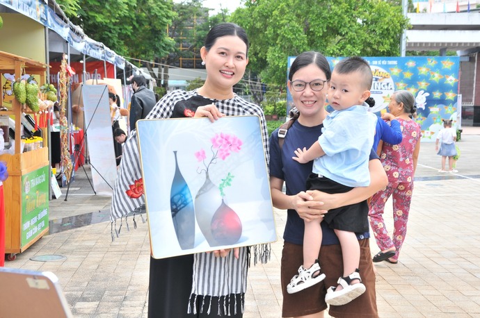 Doanh nghiệp Trà mãng cầu Thiên Hương bán tranh gây quỹ tiếp sức cho bà con mùa bão lũ tại ngày hội.