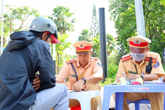 Trong hình: Tổ công tác lập biên bản xử phạt người điều khiển phương tiện vi phạm về an toàn giao thông.