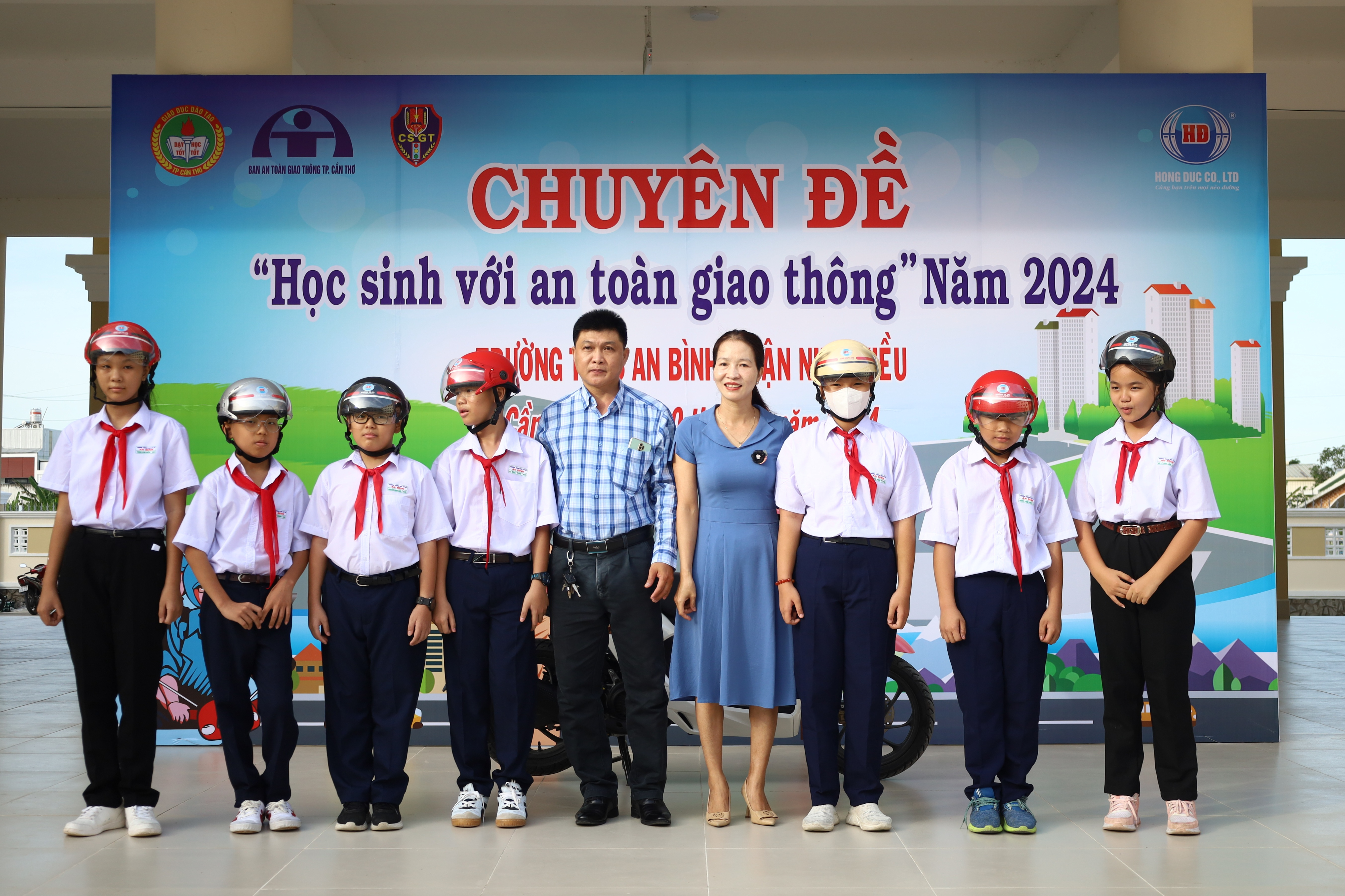 Bà Phan Thị Ngon - Đai diện Ban An toàn giao thông TP. Cần Thơ trao tặng nón bảo hiểm cho học sinh.