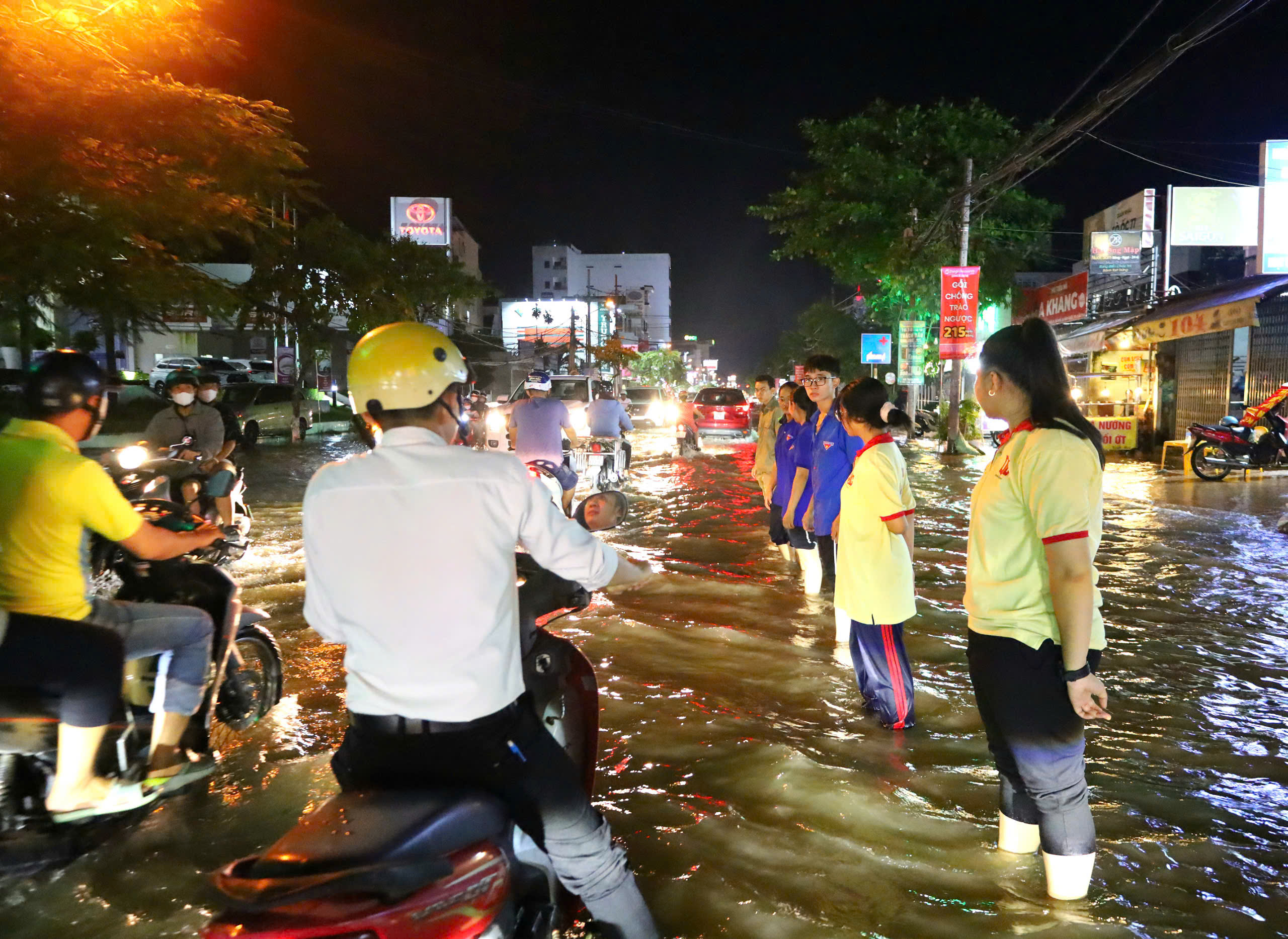 Sinh viên Trường Đại học Nam Cần Thơ tham gia hỗ trợ người dân di chuyển qua đoạn ngập sâu.