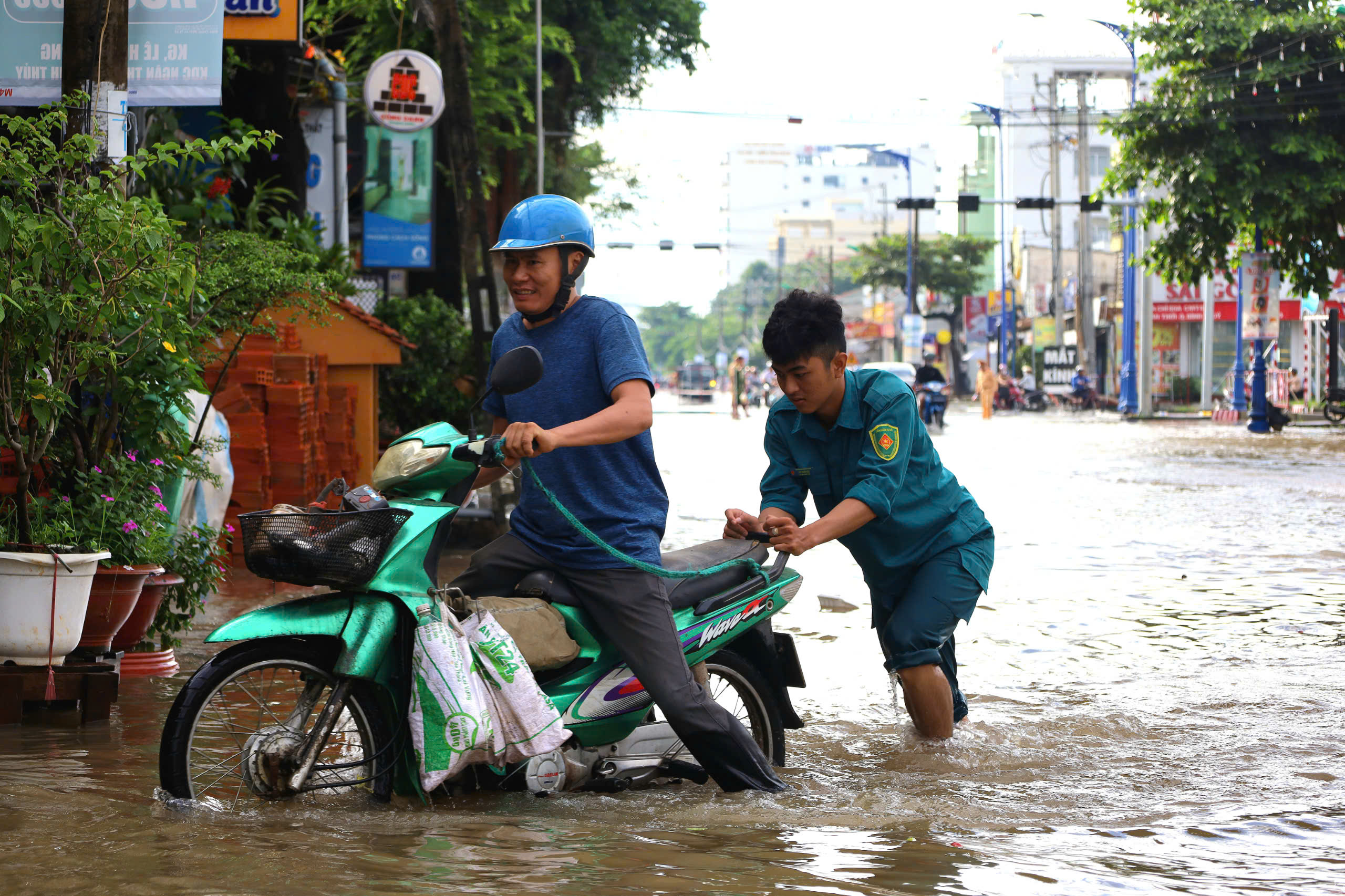 Lực lượng Quân quân tự vệ phường Bùi Hữu Nghĩa, quận Bình Thủy hỗ trợ người dân bị tắt máy xe.