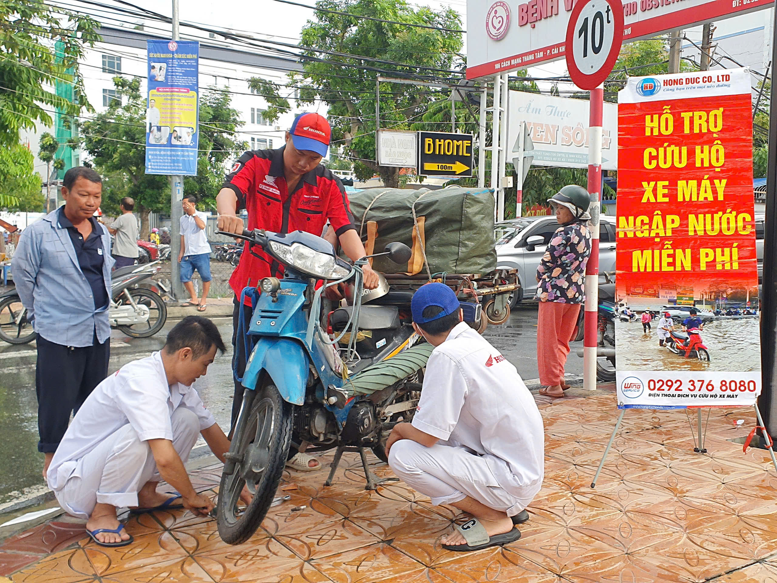 Nhân viên Công Ty TNHH Hồng Đức hỗ trợ người dân sửa xe miễn phí.