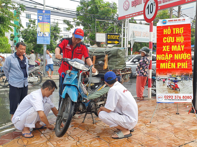 Nhân viên Công Ty TNHH Hồng Đức hỗ trợ người dân sửa xe miễn phí.