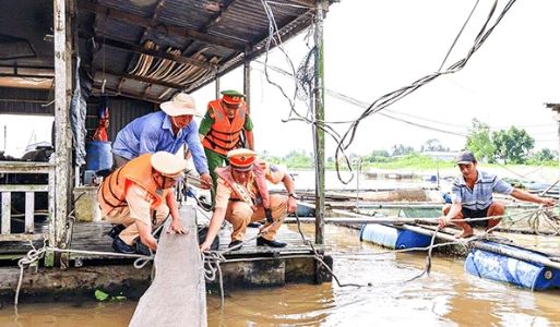 Lực lượng cảnh sát giao thông phối hợp hỗ trợ người dân gia cố, chằng buộc lồng bè. Ảnh: Công an TP Cần Thơ