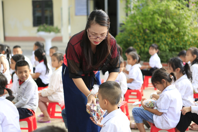 Các cán bộ, phóng viên đoàn công tác Tạp chí Gia đình Việt Nam cùng các nhà hảo tâm trao quà cho các em học sinh.